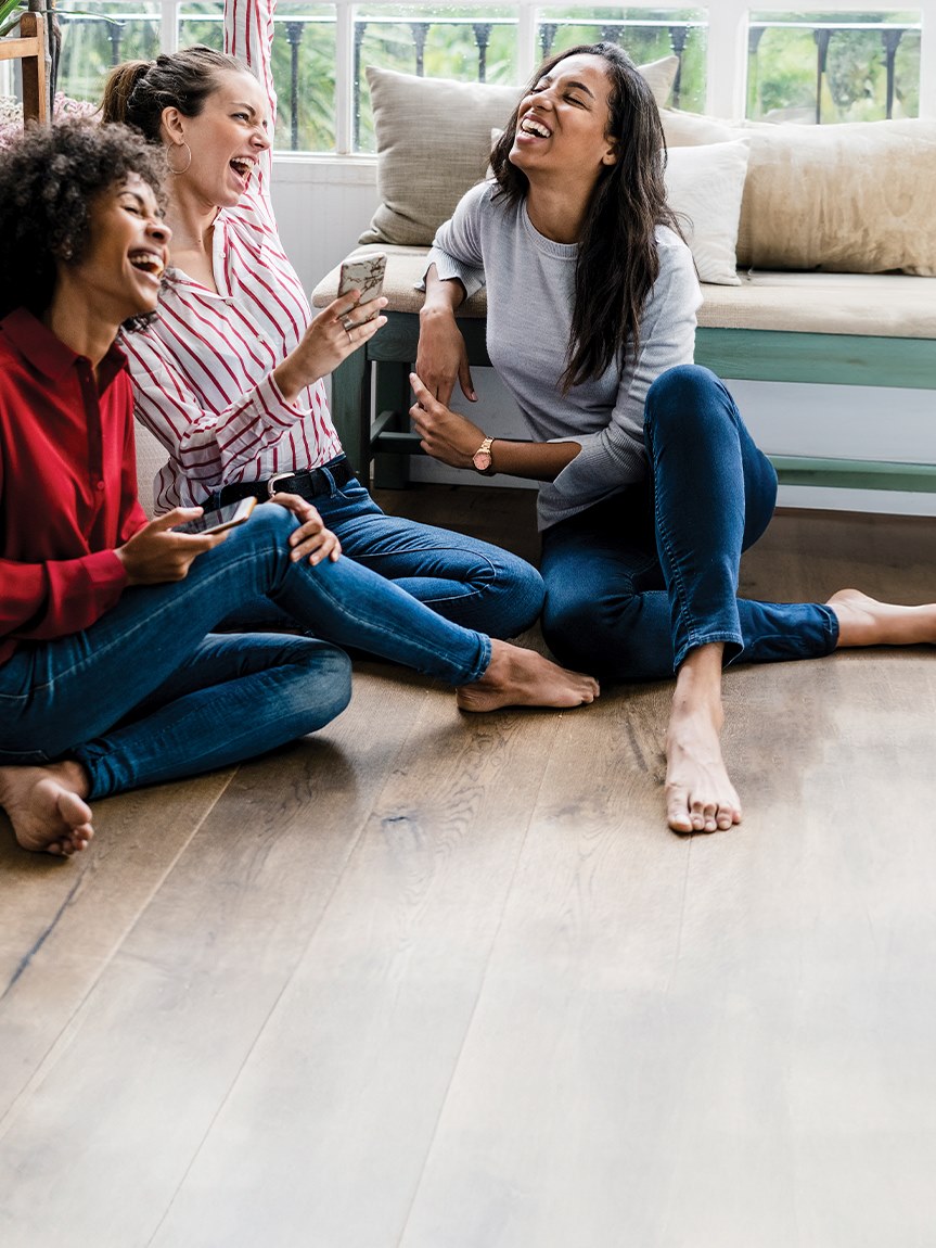 Friends in a living room with a light hardwood floor